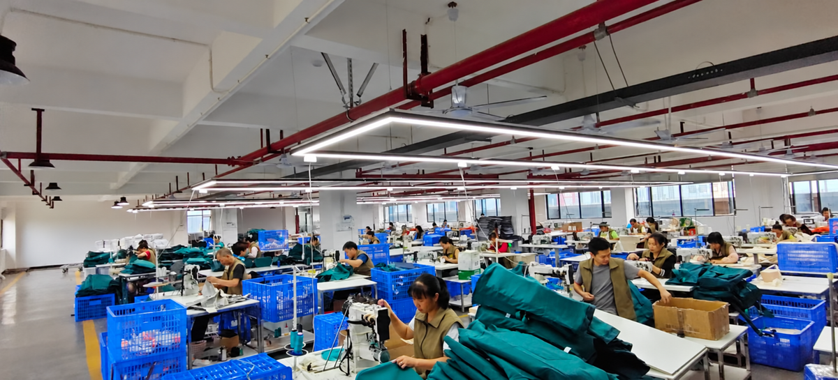 Bag manufacturing workshop with staff preparing and sewing bag components