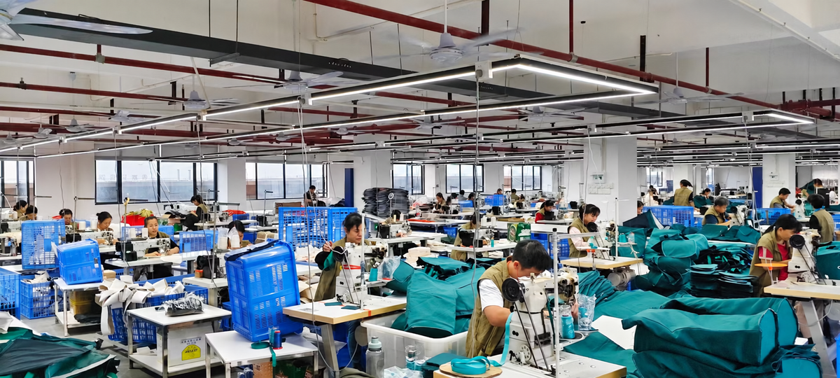 Bag manufacturing workshop with staff preparing and sewing bag components