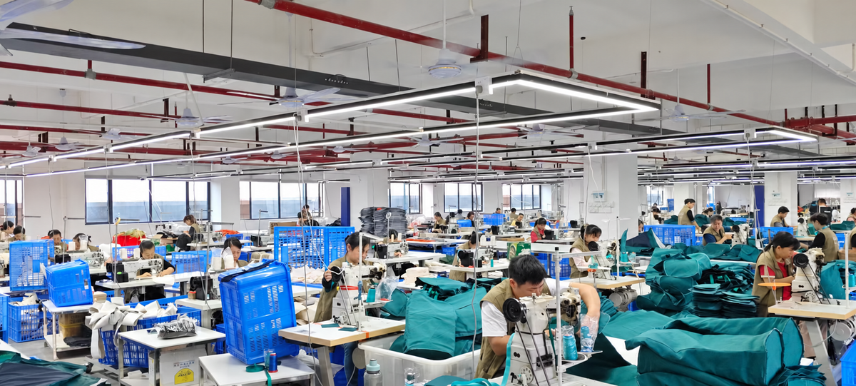 Bag manufacturing workshop with staff preparing and sewing bag components