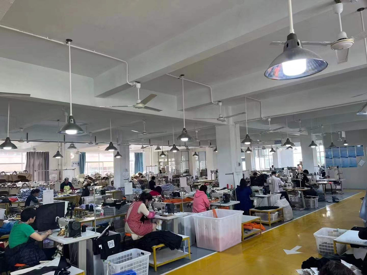 Workers sewing and handling bag components at industrial sewing stations.