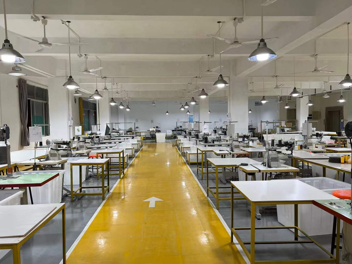 Industrial sewing machines and component baskets arranged on both sides of a workshop aisle.
