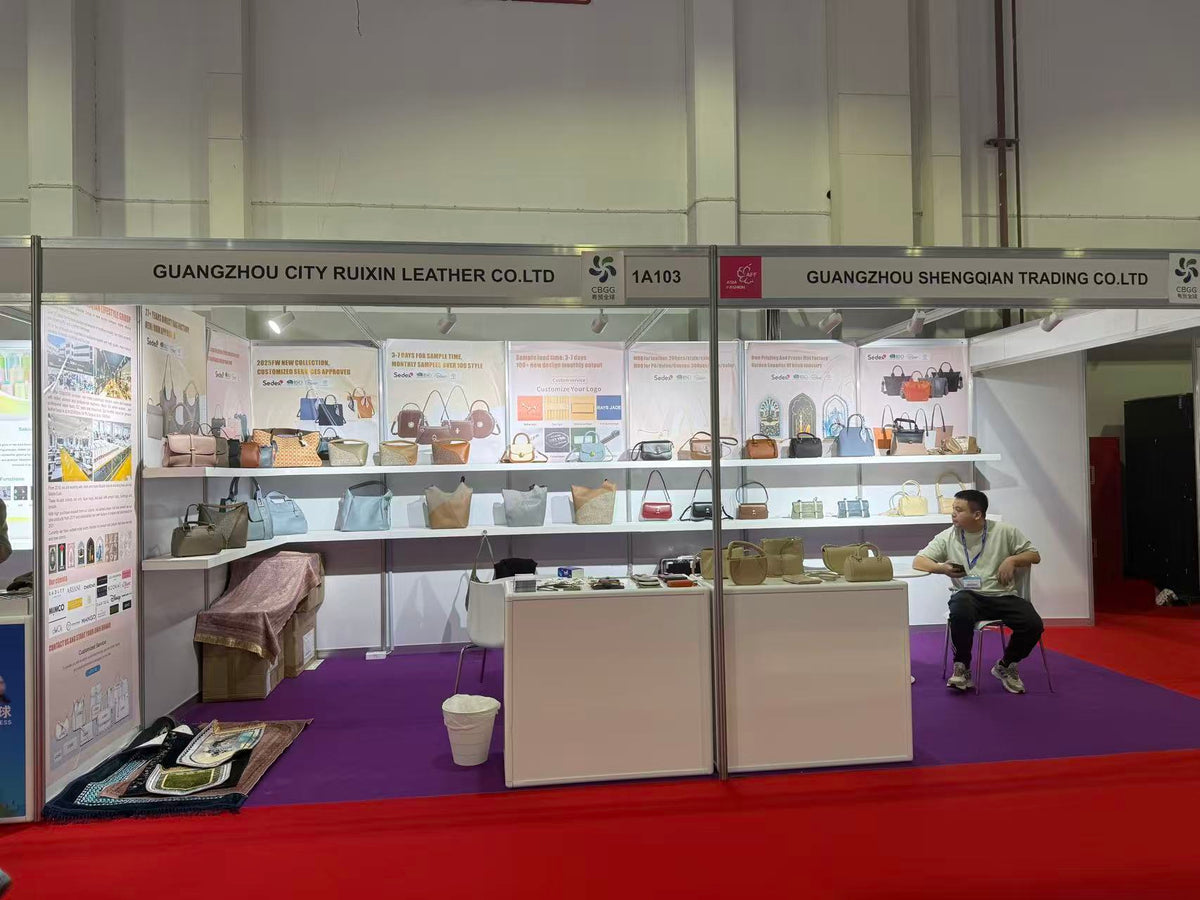 Front view of a handbag exhibition booth with totes and small bags on shelves.
