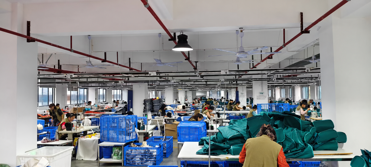 Bag manufacturing workshop with staff preparing and sewing bag components