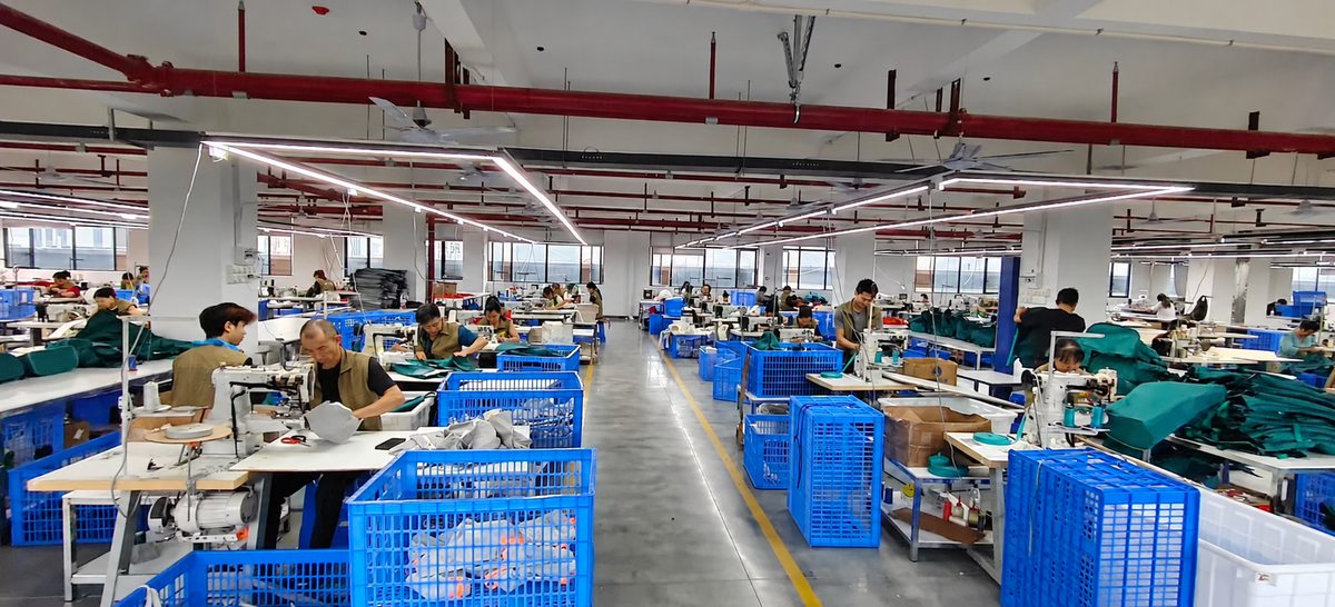Bag manufacturing workshop with staff preparing and sewing bag components