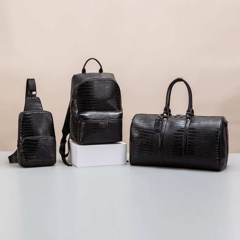 Black croc-effect sling bag, backpack and duffel bag displayed together