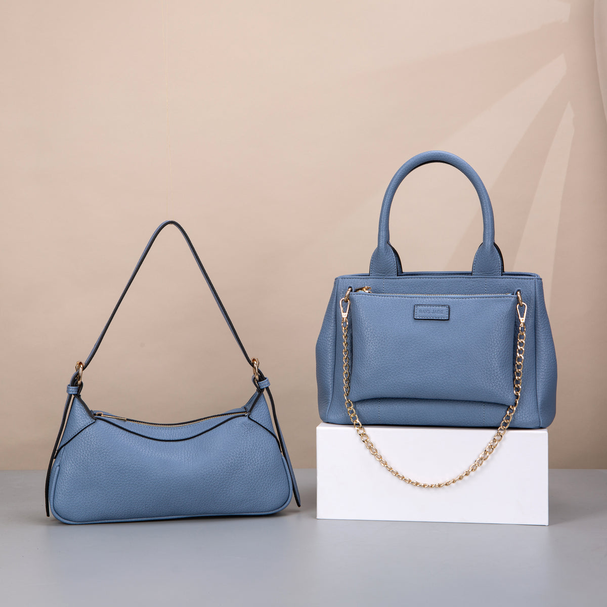 Blue textured hobo and top-handle bags with gold-tone chain details