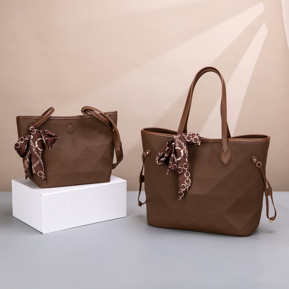 Two brown totes with contrast trim, side tabs and patterned scarf bows
