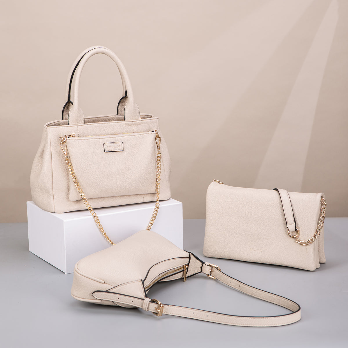 Cream textured tote and small shoulder bags with chain details