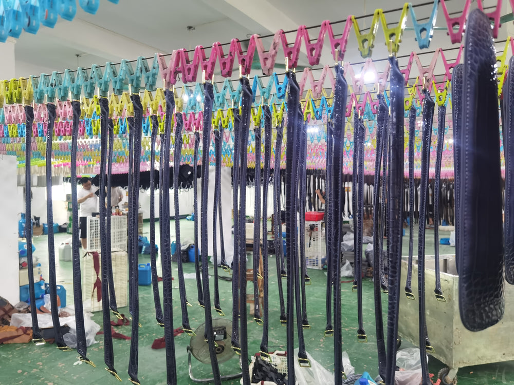 Rows of handbag straps hanging in the workshop