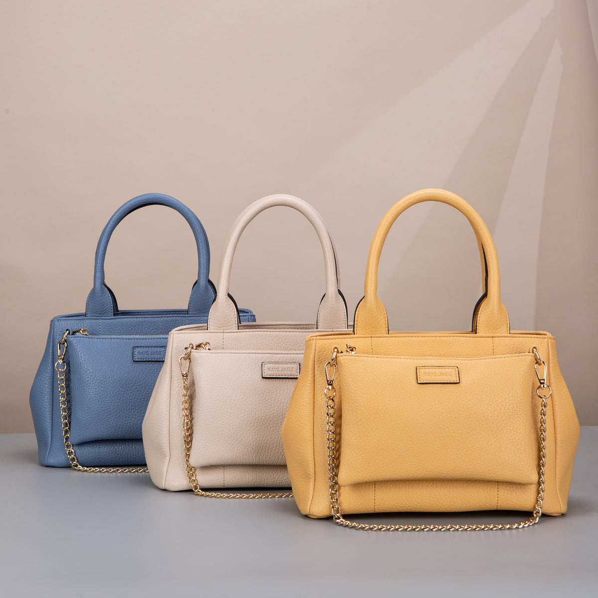 Blue, cream and yellow textured handbags with front zip pouches and chain details